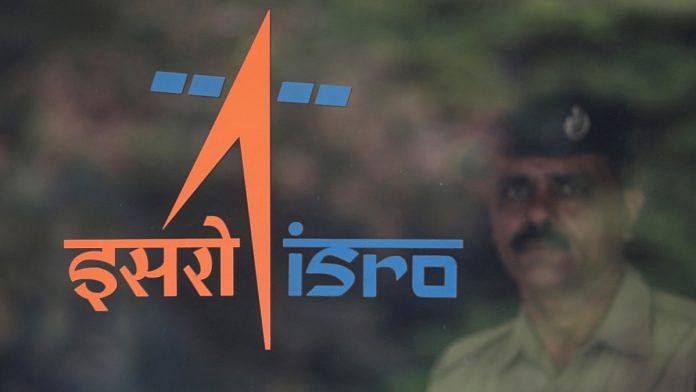 File photo of A security guard stands behind the logo of Indian Space Research Organisation (ISRO) at its headquarters in Bengaluru | Reuters