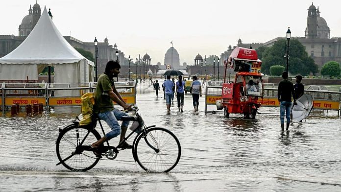 A cyclist rides through the waterlogged Kartavya Path following the incessant monsoon rain, in New Delhi on Sunday | ANI