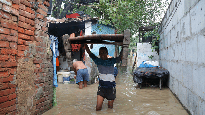 Locals wade through knee-deep water in the Yamuna Bazar area near Old Yamuna Bridge on Tuesday I Suraj Singh Bisht | ThePrint