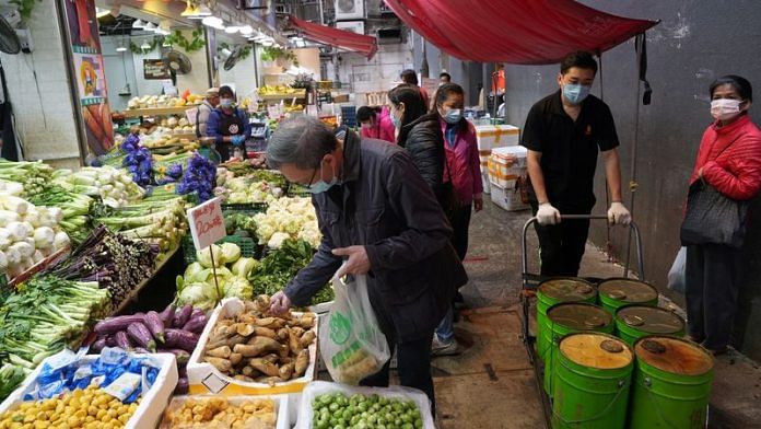 Customers wearing face masks shop for vegetables at a wet market in Tsuen Wan, following the coronavirus disease (COVID-19) outbreak in Hong Kong, China February 8, 2022/Reuters