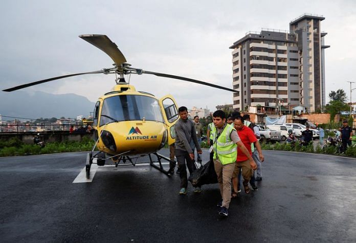 People carry the body of a person killed in a helicopter crash belonging to Manang air, at Tribhuvan University Teaching Hospital in Kathmandu | Reuters