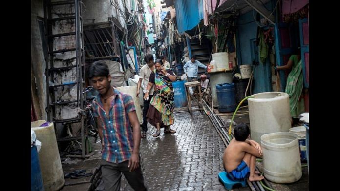 Residents walk in an alley in Dharavi, one of Asia's largest slums, in Mumbai | Reuters