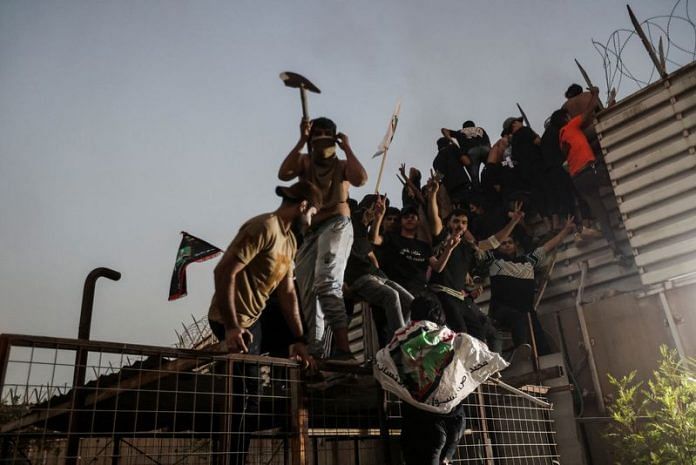 Protesters climb a fence as they gather near the Swedish embassy in Baghdad, on 20 July 2023 | Reuters/Ahmed Saad