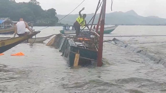 A man stands on the capsized passenger boat in Binangonan, Rizal province, Philippines, July 27, 2023 in this screen grab taken from a video by Philippine Coast Guard/Reuters