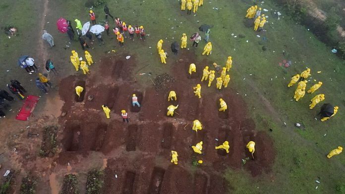 A drone view shows members of rescue teams prepare graves to bury the victims after a landslide following heavy rains in Raigad district, Maharashtra, on 202 July 2023 | Reuters