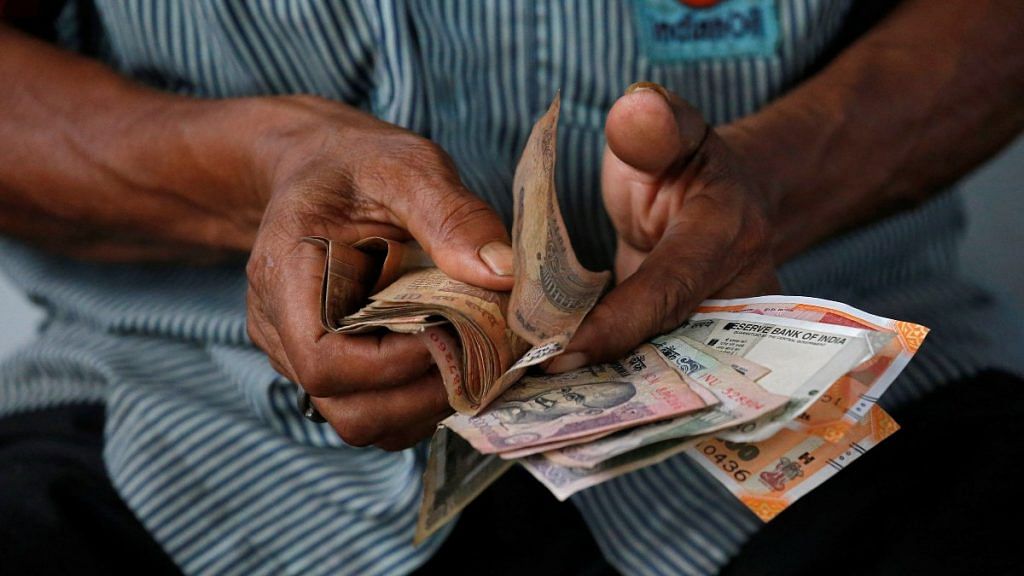 An attendant at a fuel station arranges Indian rupee notes in Kolkata | Reuters file photo