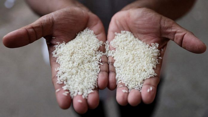 A man compares different grains of rice at a wholesale market in Navi Mumbai, India | Reuters