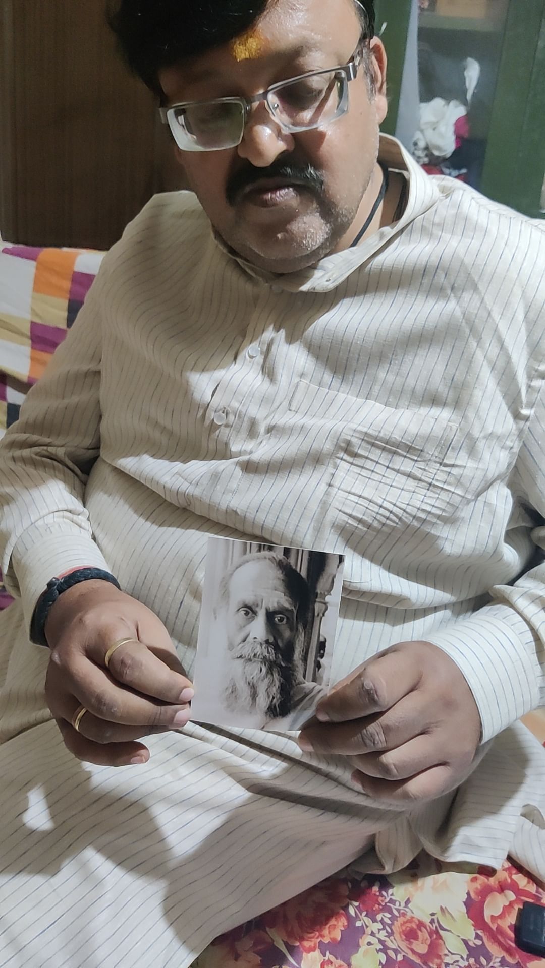 Shailendra Pathak with photographs of his uncles who were caretakers of a room in Gyanvapi mosque complex | Sonal Matharu, ThePrint