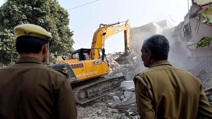 File photo of police guarding the area, as the Prayagraj Development Authority's bulldozer demolishes a house belonging to a gun store owner | Representational image | ANI file photo