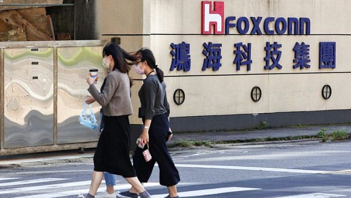 People walk past the logo of Foxconn outside the company's building in Taipei, Taiwan November 9, 2022 | Reuters
