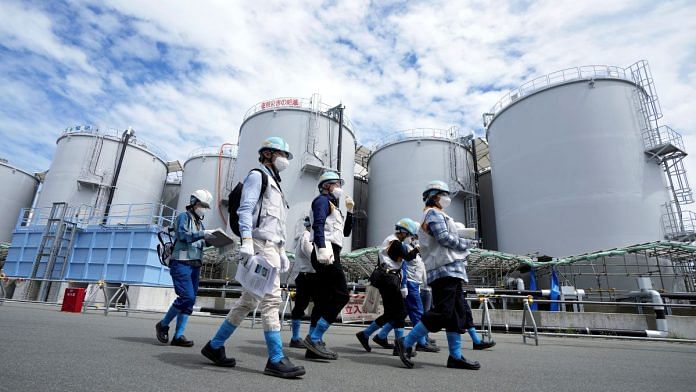 Journalists are guided along near tanks containing treated radioactive wastewater during a tour for foreign media, in Okuma town, northeastern Japan | Eugene Hoshiko/Pool via Reuters