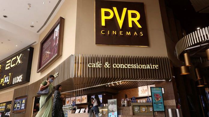 Women walk outside a PVR movie theatre in Mumbai, India, March 29, 2022 | Reuters
