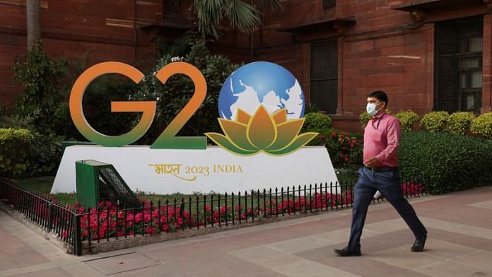 A man walks past a model of G20 logo outside the finance ministry in New Delhi, India, March 1, 2023 | Reuters