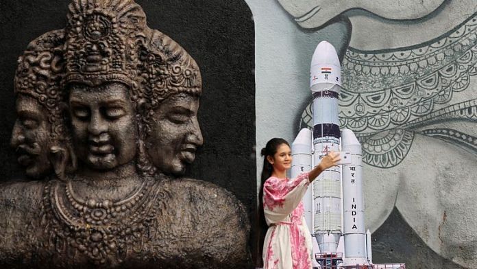 A young woman takes a selfie along with a cutout of the Chandrayaan 3 Launch Vehicle Mark-III outside a temple in Mumbai, India, July 14, 2023 | Reuters