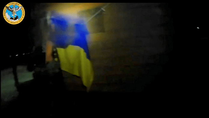 A Ukrainian soldier hangs the country's flag during a 'special operation' at a location given as near Olenivka and Mayak settlements, Crimea | Ukrainian Main Directorate of Intelligence/Reuters