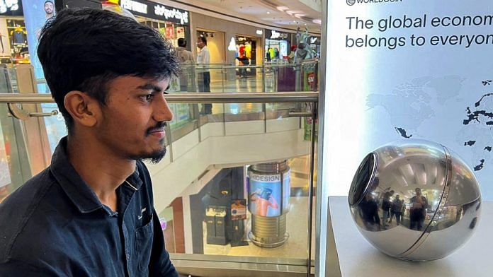 Kaleem, 22, an engineer in Bengaluru, signs up for WorldCoin by having his eyes scanned by the spherical device in Mantri Square Mall in Bengaluru | Reuters