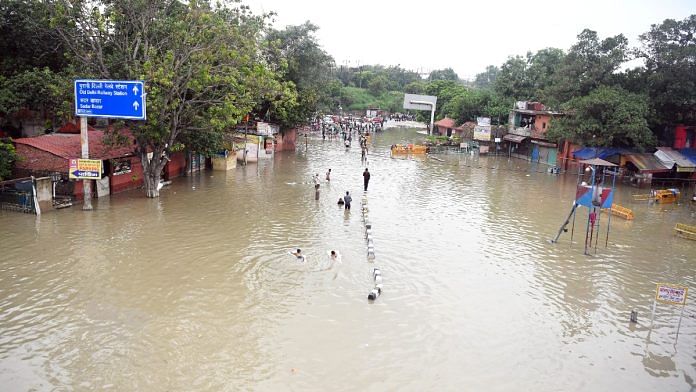 File photo of people walking through a flooded area at Yamuna Bazar in Delhi last month | ANI