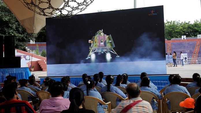 People watch a live stream of Chandrayaan-3 spacecraft's landing on the moon, inside an auditorium of Gujarat Science City in Ahmedabad, on 23 August 2023 | Reuters