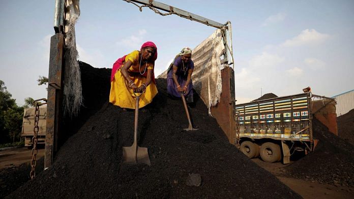 Workers unload coal from a supply truck at a yard on the outskirts of Ahmedabad, India | Reuters