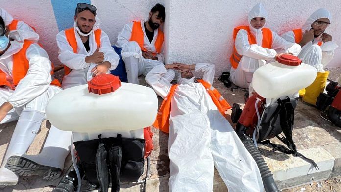 Health workers get rest after they sanitise the destruction areas following deadly floods, in Derna, Libya | Reuters