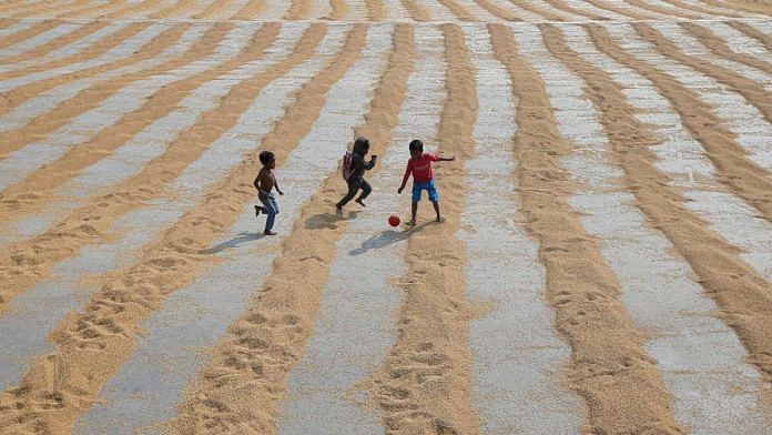 Children play with a ball after rice is spread for drying at a rice mill on the outskirts of Kolkata, India | Reuters file photo