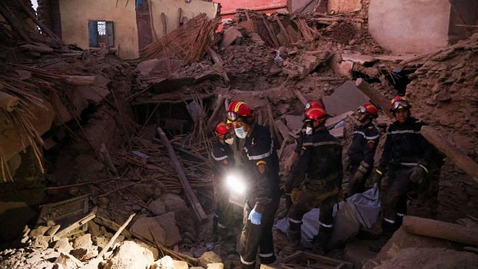 Emergency workers carry a dead body, in the aftermath of a deadly earthquake, in Amizmiz, Morocco | Reuters