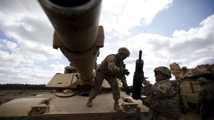Members of the U.S. 2nd Battalion, 7th Infantry Regiment, 1st Brigade Combat Team, 3rd Infantry Division get ammunition to the Abrams tank during an exercise at Mielno range near Drawsko-Pomorskie April 16, 2015/Reuters