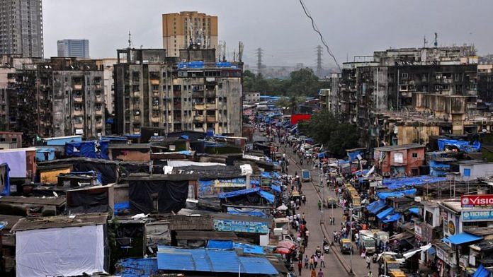 People and vehicles move past shanties in Dharavi, one of Asia's largest slums, in Mumbai, India, August 1, 2023 | Reuters