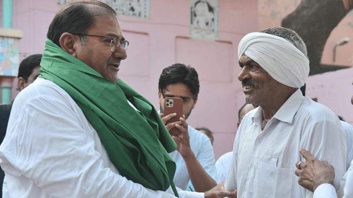 File photo of INLD leader Abhay Singh Chautala with a supporter | Pic credit: X/@AbhaySChautala