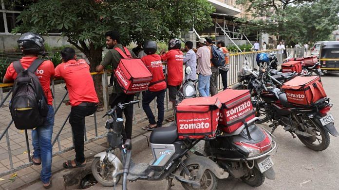 Gig workers wait in line to collect their delivery order outside a mall in Mumbai | Reuters/Francis Mascarenhas