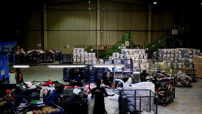 Wokers sort used clothes for packaging at a warehouse in Sant Esteve Sesrovires, on the outskirts of Barcelona, Spain | Reuters