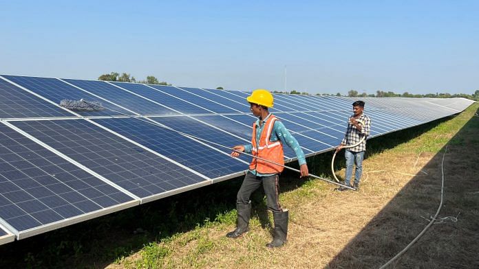Workers clean panels at a solar park in Modhera, India's first round-the-clock solar-powered village, in the western state of Gujarat, India | Reuters File photo