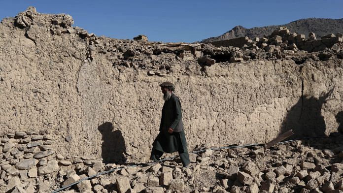 An Afghan man walks past a damaged house after the recent earthquake in Wor Kali village in the Barmal district of Paktika province, Afghanistan | Reuters