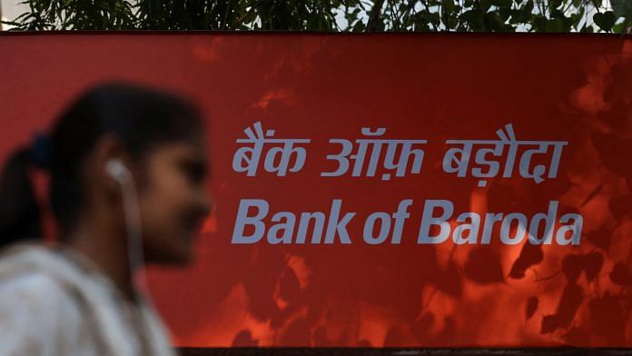A woman walks past a signboard of Bank of Baroda outside their branch office in New Delhi, India | Reuters file photo