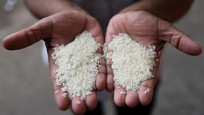 A man compares different grains of rice at a wholesale market in Navi Mumbai, India | Reuters