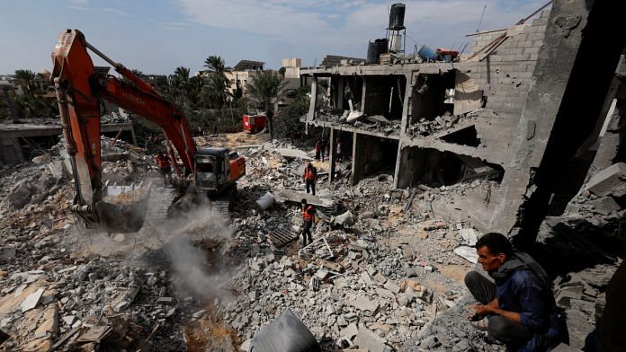 Palestinians search for casualties under the rubble at a site of a house destroyed by Israeli strikes in Khan Younis in the southern Gaza Strip | Reuters