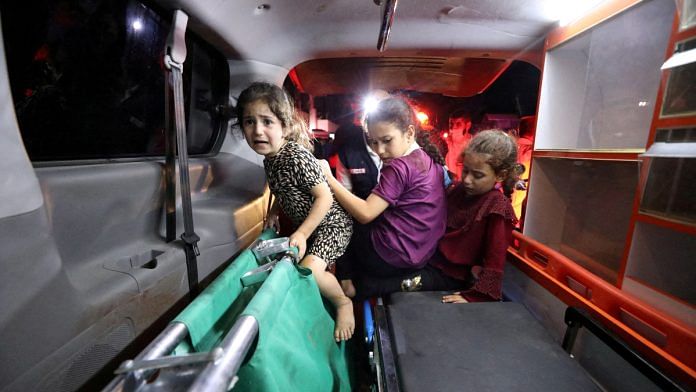 Children sit in the back of an ambulance at Shifa Hospital after hundreds of Palestinians were killed in a blast at Al-Ahli hospital in Gaza that Israeli and Palestinian officials blamed on each other in Gaza City, Gaza Strip, October 17, 2023 | Reuters