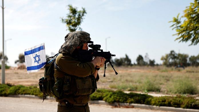 An Israeli soldier secures an area, following a deadly infiltration by Hamas gunmen from the Gaza Strip, in Kibbutz Kissufim in southern Israel | Reuters