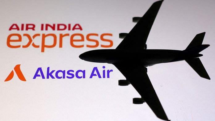 A miniature airplane is placed on the displayed Air India Express and Akasa Air logos, in this illustration | Reuters