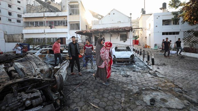 People inspect area of Al-Ahli Arabi Baptist Hospital in Gaza where hundreds were killed in a blast, Wednesday | REUTERS/Mohammed Al-Masri