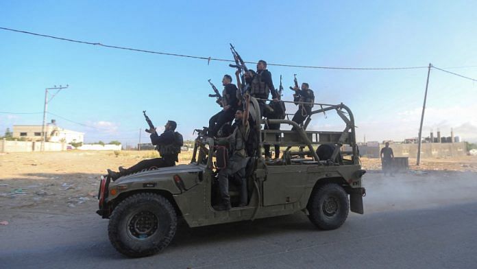 Hamas operatives riding seized Israeli military vehicle in northern Gaza Strip on 7 October, 2023 | REUTERS/Ahmed Zakot