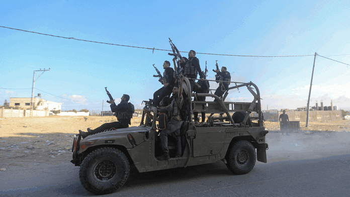 Palestinian militants riding Israeli military vehicle in the northern Gaza Strip, Saturday | REUTERS/Ahmed Zakot