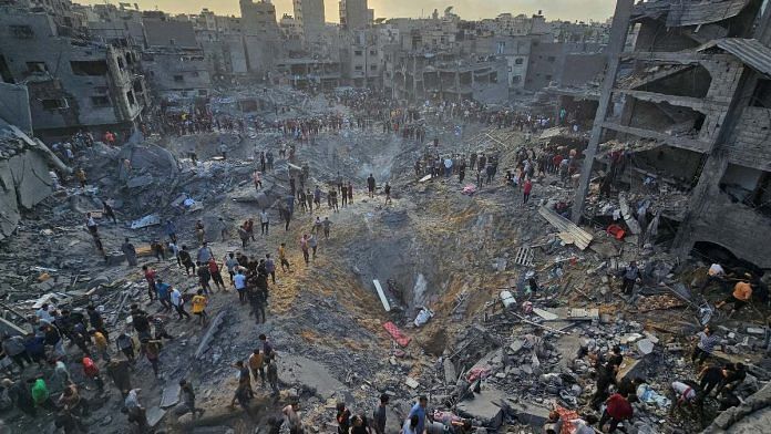 Palestinians search for casualties at the site of Israeli strikes on houses in Jabalia refugee camp in the northern Gaza Strip, on 31 October 2023 | Reuters