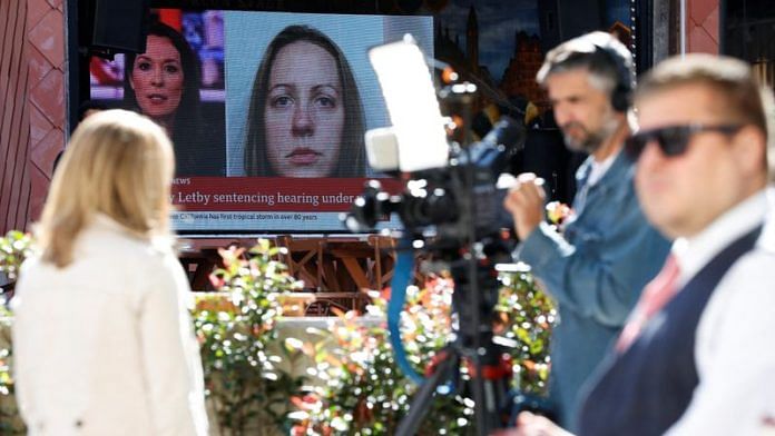 Members of the media work near a large screen showing a picture of convicted hospital nurse Lucy Letby, ahead of her sentencing, outside the Manchester Crown Court, in Manchester, Britain, August 21, 2023. REUTERS/Phil Noble/File Photo