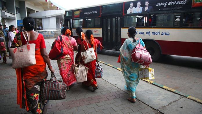 Women hop from one bus to another with their backpacks and luggage packed with food | Manisha Mondal, ThePrint