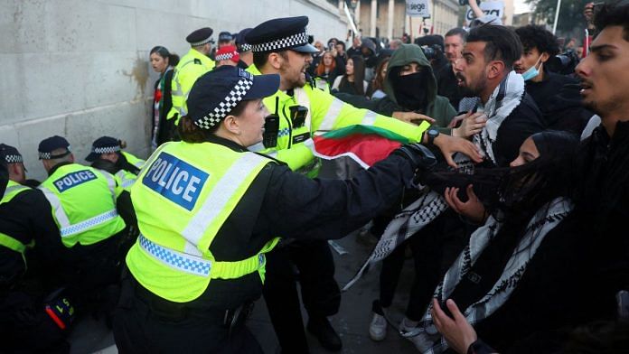Police officers detain with demonstrators as they protest in solidarity with Palestinians | Reuters