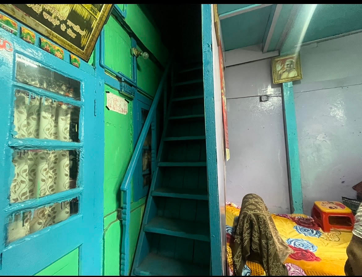 A narrow wooden staircase leads to the top floor of Asha Devi's house | Photo: Monami Gogoi, ThePrint