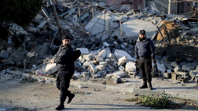 Palestinian policemen loyal to Hamas stand guard at the site of a Hamas-run insurance office after it was destroyed by an Israeli air strike in Gaza City on Tuesday. (REUTERS Photo) | via ANI