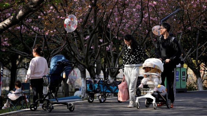 A parents pushes a stroller with a baby in a park in Shanghai, China | Reuters