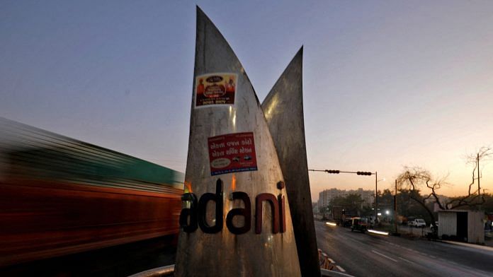 Traffic moves past the logo of the Adani Group installed at a roundabout on the ring road in Ahmedabad, India, February 2, 2023. REUTERS/Amit Dave/File Photo